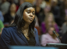 A woman standing at a podium. Links to Beneficiary Designations